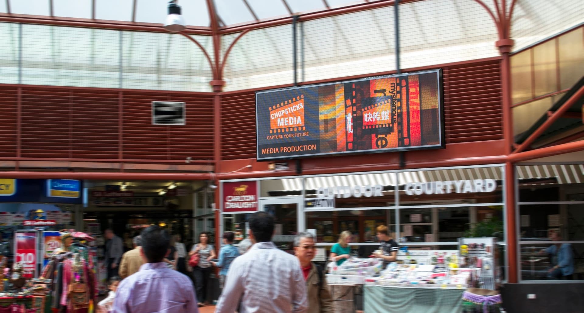 Wide indoor LED screen mounted above a shopfront in Adelaide Central Market.