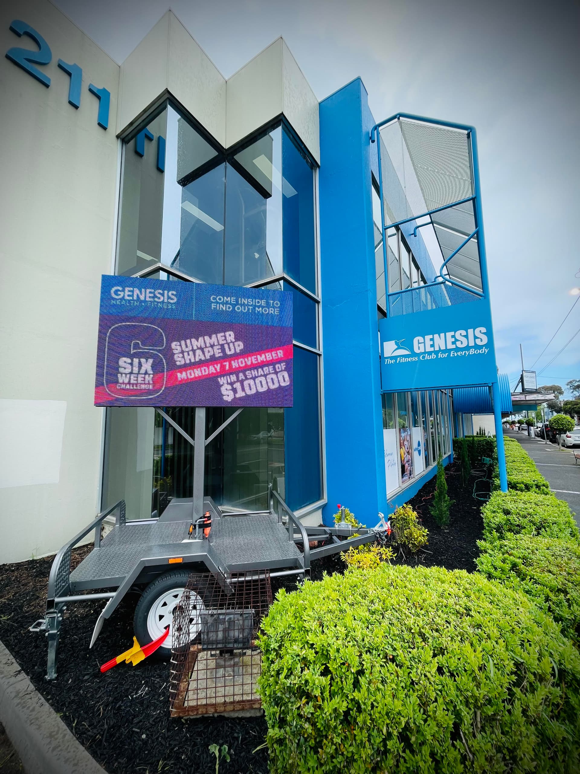 LED trailer screen outside Genesis Fitness Caulfield, showing a summer challenge promotion.