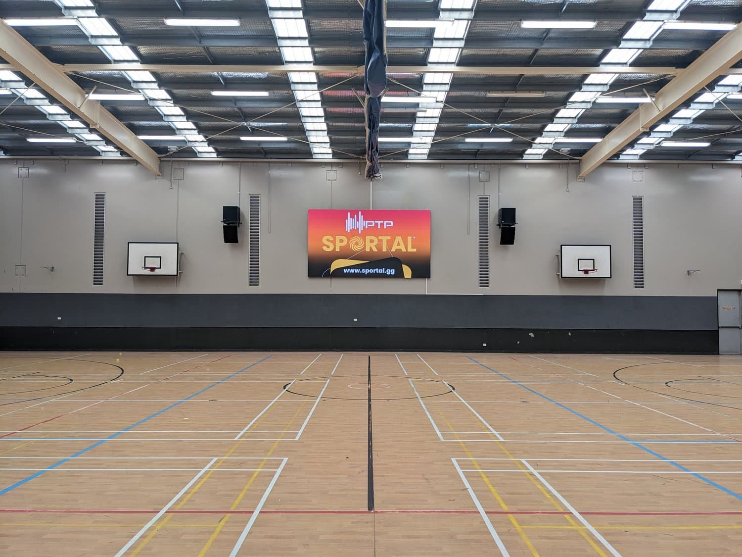 Sportal LED scoreboard on the wall of an indoor basketball court at Plympton International College.